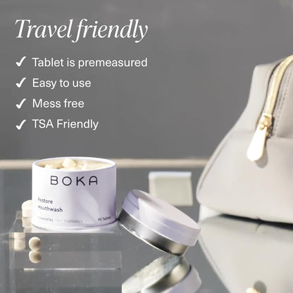 Open Restore Mouthwash Tablets beside a gray travel bag to remineralize your teeth on the go.