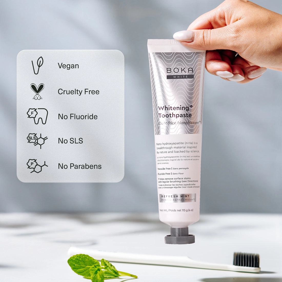 A hand holds Refresh Mint Whitening* n-Ha Toothpaste; vegan, cruelty free, nano-hydroxyapatite.
