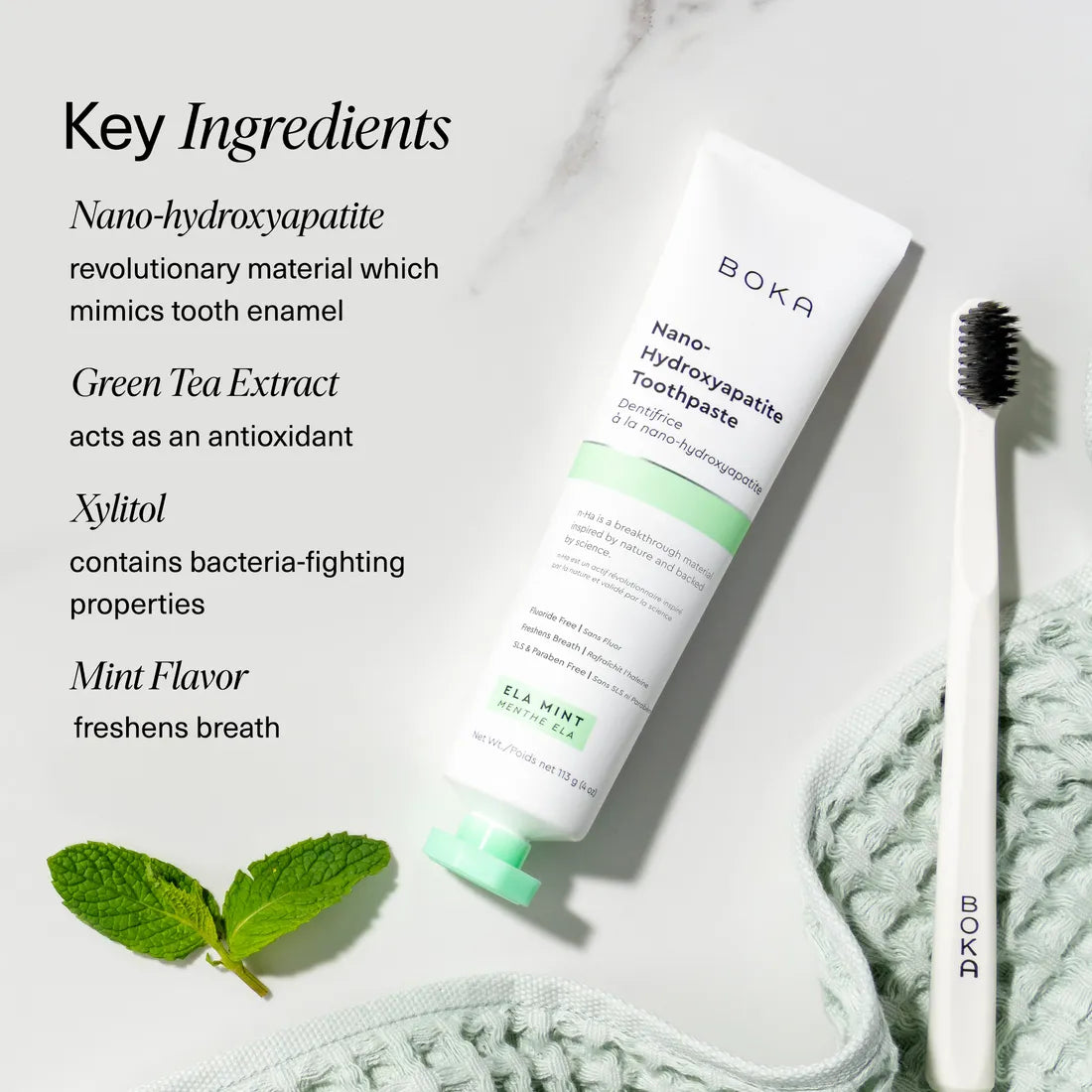 Boka Ela Mint n-Ha Toothpaste set with toothbrush, mint leaves, and key biomimetic minerals.