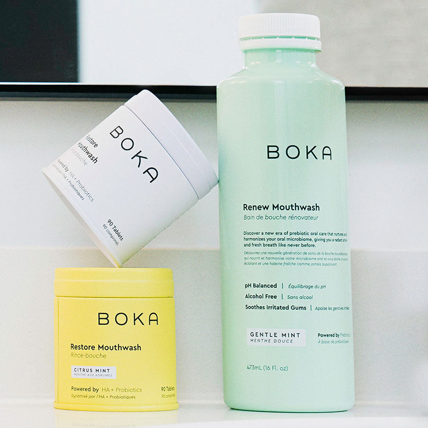Three Boka mouthwash containers in white, yellow, and mint green are displayed on a counter.