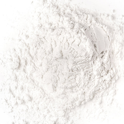 White powder scattered on a white surface, appearing soft and finely textured.