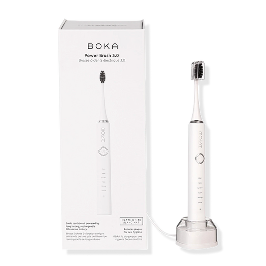 A white Boka Electric Toothbrush 3.0 with charcoal bristles stands by its box and charging base.