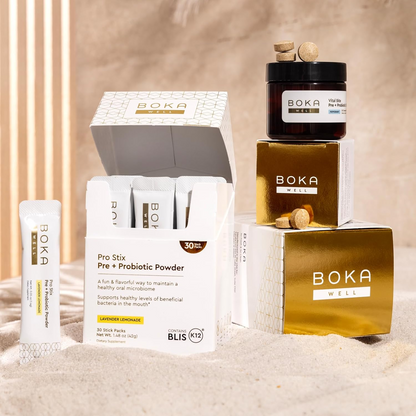 Pro Stix Pre + Probiotic Powder jars arranged on sand with sunlight and shadows.