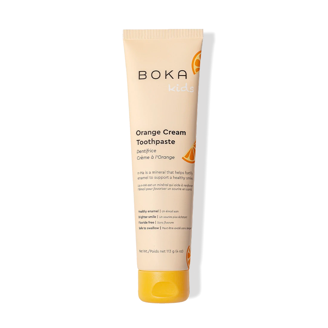 Orange Cream n-Ha Toothpaste for kids with nano-hydroxyapatite and orange slices on black background.