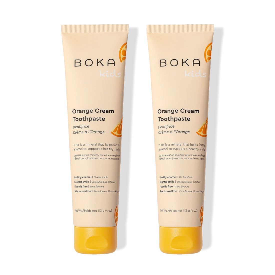 Two tubes of Orange Cream n-Ha Toothpaste stand side by side to help remineralize teeth.