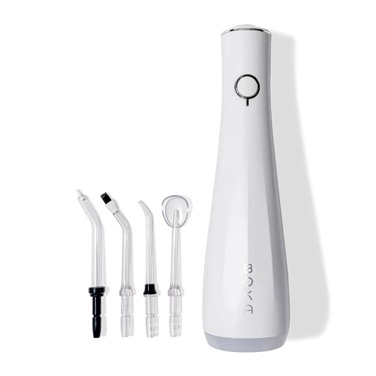 Power Flosser in white with 4 nozzles for healthy gums and teeth, shown on a black background.